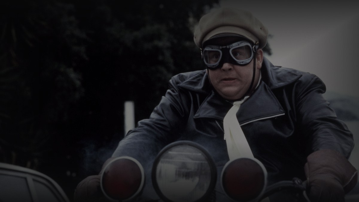 Still from Armed and Dangerous (1986) — 16:9 still from Letterboxd (1200x675 crop variant), baked through scripts/bake_dark_photo.py at default factor 0.45